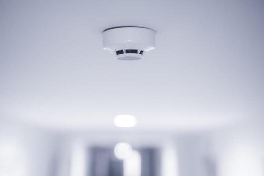 Smoke detector fitted to a pale ceiling